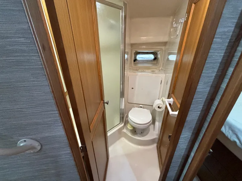 Slide: The Image of 2000 Bayliner 3788 Command Bridge Motoryacht bathroom with shower, toilet, and wooden cabinetry. - 25