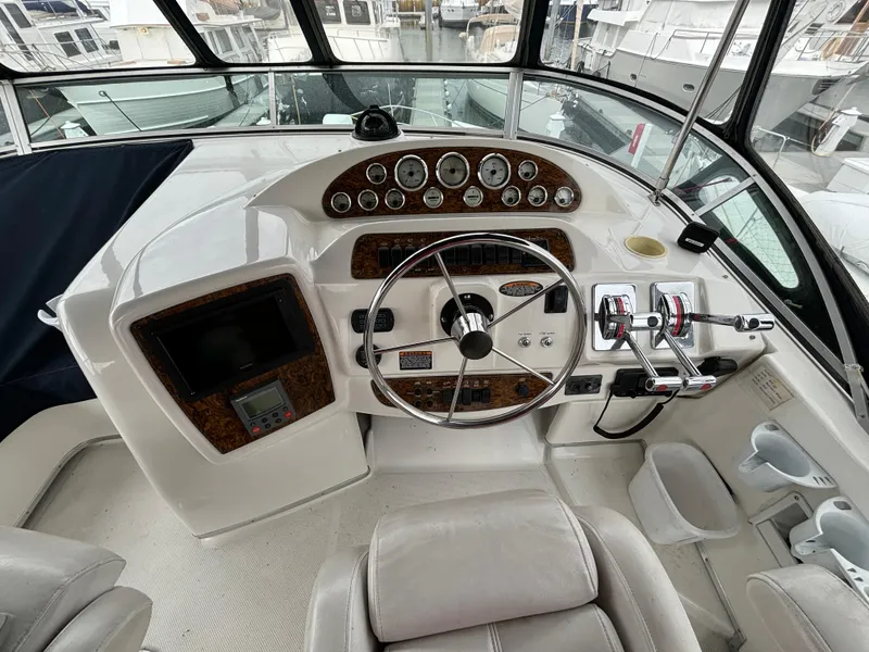Slide: The Image of 2000 Bayliner 3788 Command Bridge Motoryacht helm with steering wheel and control panel. - 43