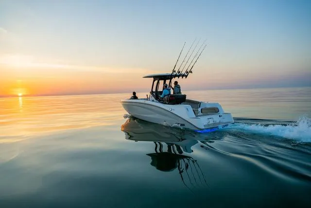 Slide: The Image of 2024 Yamaha Boats 255 FSH Sport H cruising at sunset on calm waters. - 26