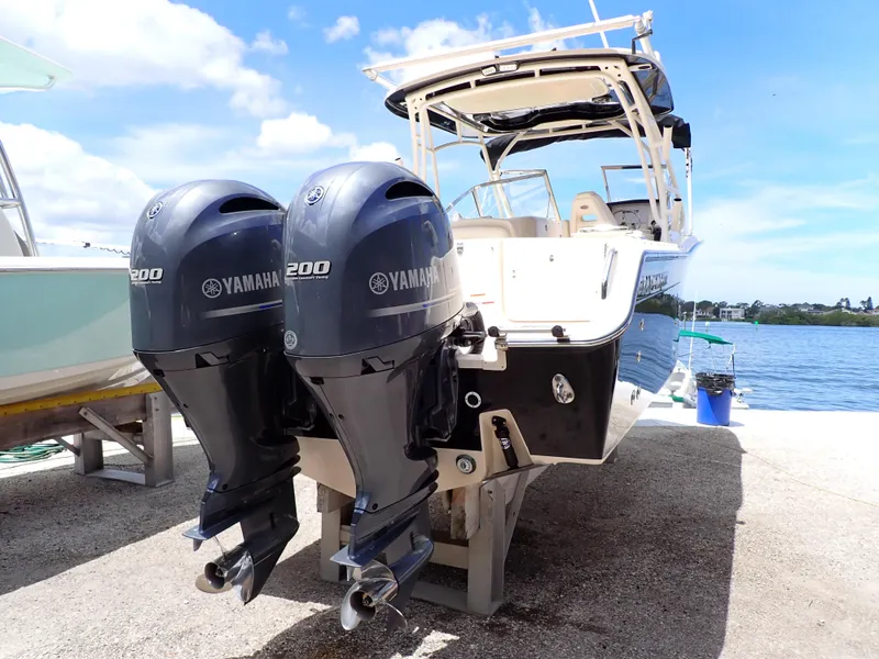 Slide: The Image of 2019 Grady-White Freedom 275 boat with twin Yamaha 200 engines docked by the water. - 1