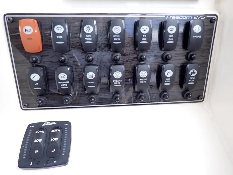 Slide: The Image of Control panel of a 2019 Grady-White Freedom 275 boat with various switches. - 21