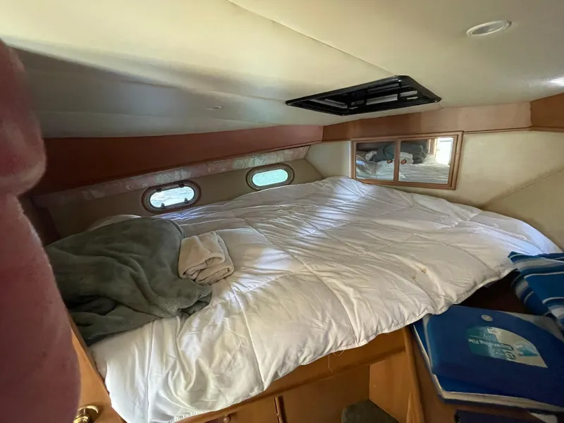 Slide: The Image of Cozy bedroom in 1994 Queenship motor yacht with porthole windows and bedding. - 16