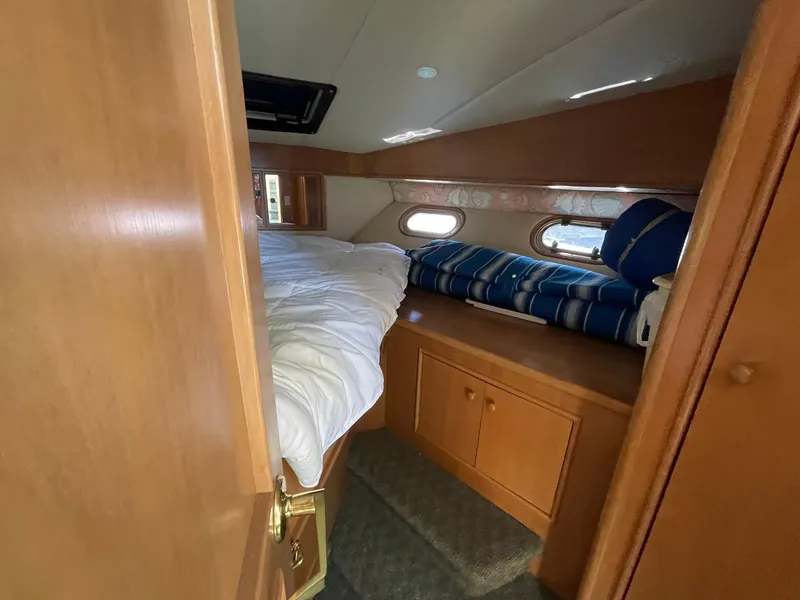 Slide: The Image of Cozy cabin interior of 1994 Queenship Motor Yacht with bed and storage. - 17