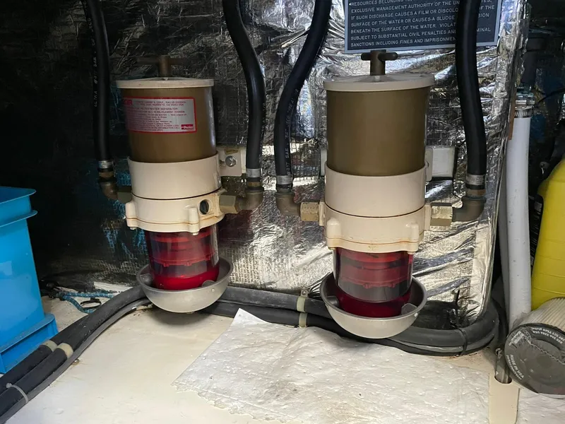 Slide: The Image of Engine room of 1994 Queenship Motor Yacht showing dual fuel filters and hoses. - 23