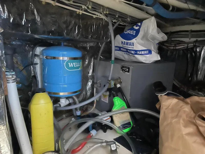 Slide: The Image of Engine room of a 1994 Queenship motor yacht with various equipment and supplies. - 24