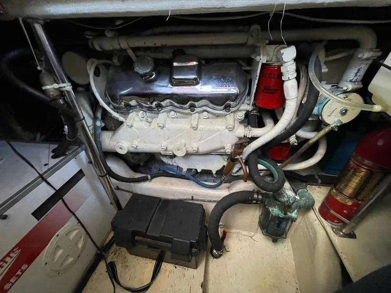 Slide: The Image of Engine room of a 1994 Queenship Motor Yacht, showcasing mechanical components and wiring. - 27