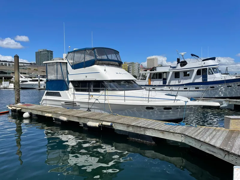 Slide: The Image of 1994 Queenship Motor Yacht docked at marina under clear blue sky. - 31