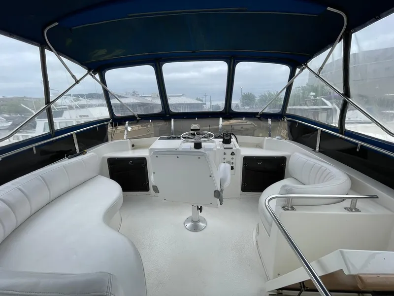 Slide: The Image of Interior view of 1994 Queenship motor yacht with white seating and helm. - 4