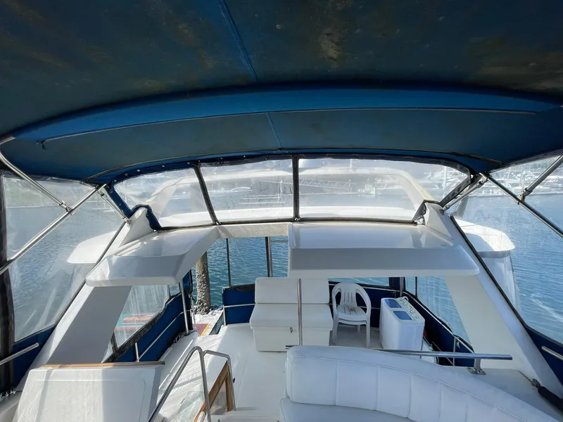 Slide: The Image of 1994 Queenship Motor Yacht interior with blue canopy and white seating, overlooking water. - 6