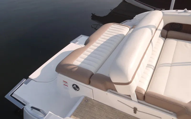 Slide: The Image of 2013 Cobalt 26SD boat with beige and white seating, docked on calm water. - 12