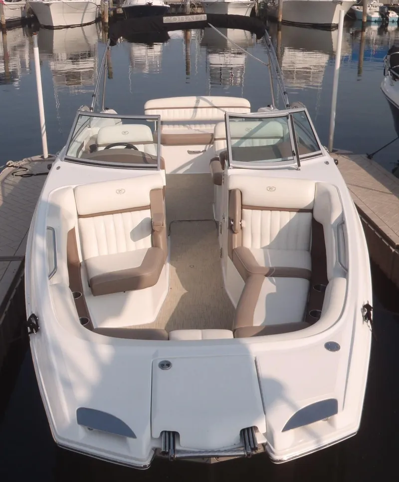 Slide: The Image of 2013 Cobalt 26SD boat with white and beige seating, docked at a marina. - 14