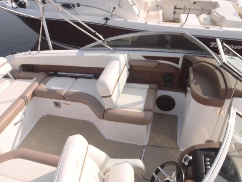 Slide: The Image of 2013 Cobalt 26SD boat interior with beige and brown seating, steering wheel, and dashboard. - 4
