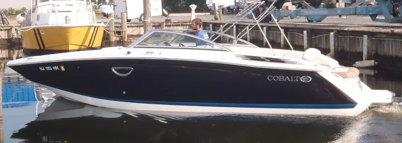 Slide: The Image of 2013 Cobalt 26SD boat docked in a marina, side view. - 8