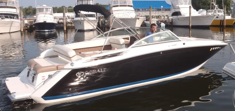 Slide: The Image of 2013 Cobalt 26SD boat docked in marina, featuring sleek design and comfortable seating. - 9
