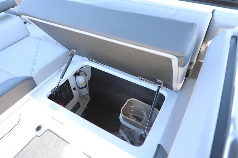 Slide: The Image of 2024 Cobalt R4 boat storage compartment with fire extinguisher and utility bin. - 17