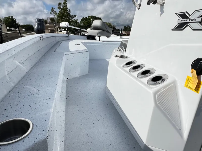 Slide: The Image of 2025 Xpress H22B HYPER-LIFT BAY boat interior with rod holders and seating. - 12
