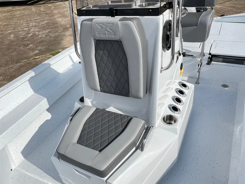 Slide: The Image of 2025 Xpress H22B Hyper-Lift Bay boat interior with cushioned seating and rod holders. - 6