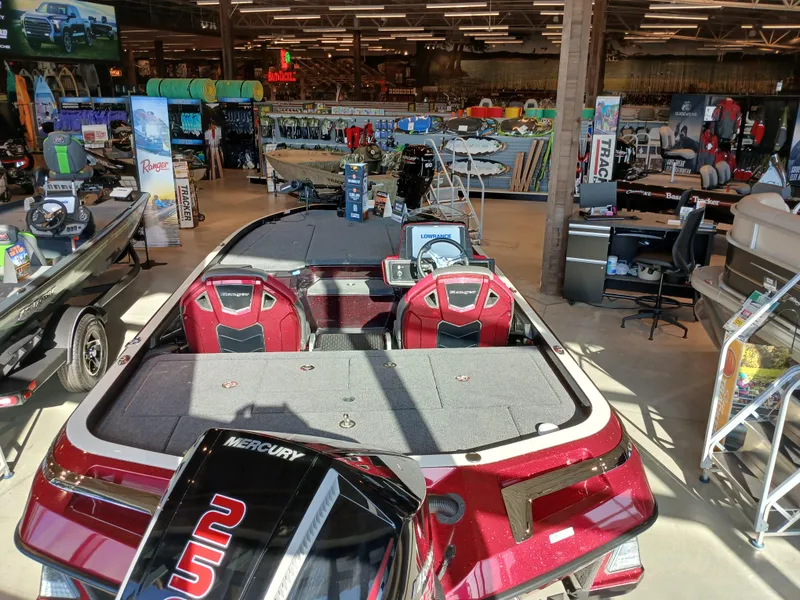 Slide: The Image of 2024 Ranger Z521R boat displayed in a showroom with fishing gear. - 21