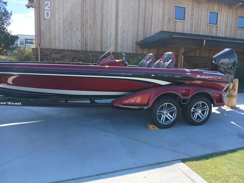 Slide: The Image of 2024 Ranger Z521R Ranger Cup Equipped boat, red and black, parked on driveway. - 3