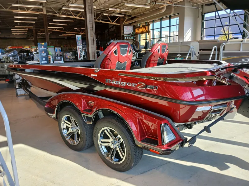 Slide: The Image of 2024 Ranger Z521R Ranger Cup Equipped boat in showroom, featuring sleek red design and dual axles. - 5