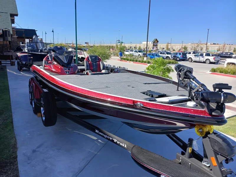 Slide: The Image of 2024 Ranger Z521R Ranger Cup Equipped boat in parking lot, red and black design. - 9