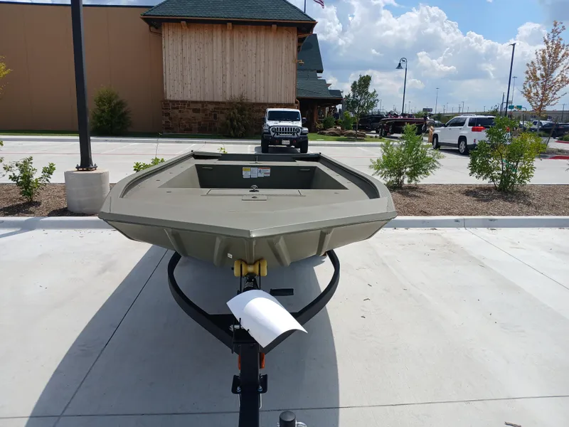 Slide: The Image of 2024 Tracker Grizzly 1754 Jon boat displayed outdoors on a sunny day. - 2