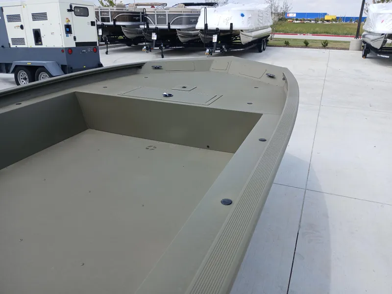 Slide: The Image of 2024 Tracker Grizzly 1754 Jon boat in a parking lot, showcasing its spacious deck. - 5