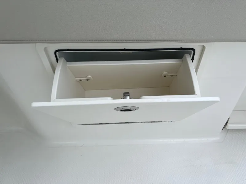 Slide: The Image of Storage compartment on a 2025 Boston Whaler 240 Vantage boat, open and empty. - 21