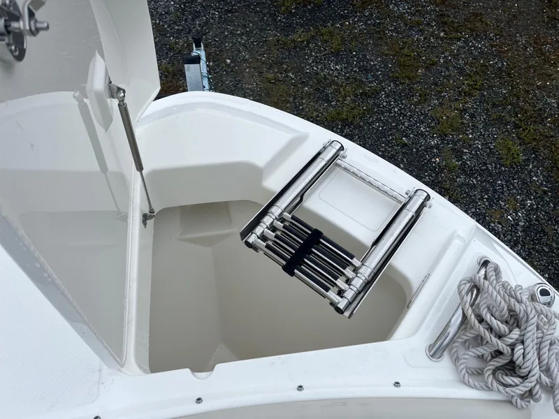 Slide: The Image of 2025 Boston Whaler 240 Vantage boat with open storage compartment and ladder. - 26