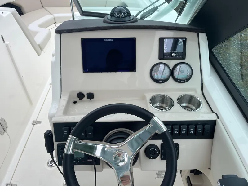 Slide: The Image of 2025 Boston Whaler 240 Vantage dashboard with steering wheel, gauges, and cup holders. - 4
