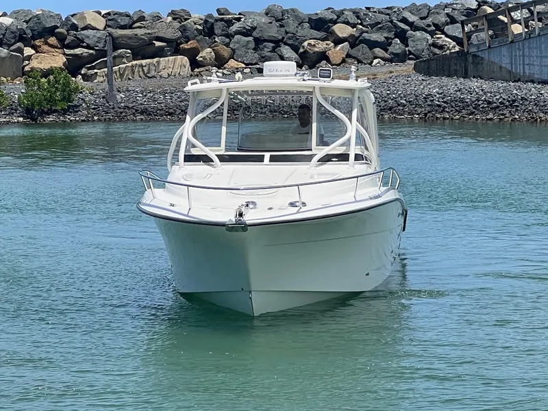 Slide: The Image of 2008 Hydra-Sports 3500VX boat cruising in calm waters near rocky shore. - 5
