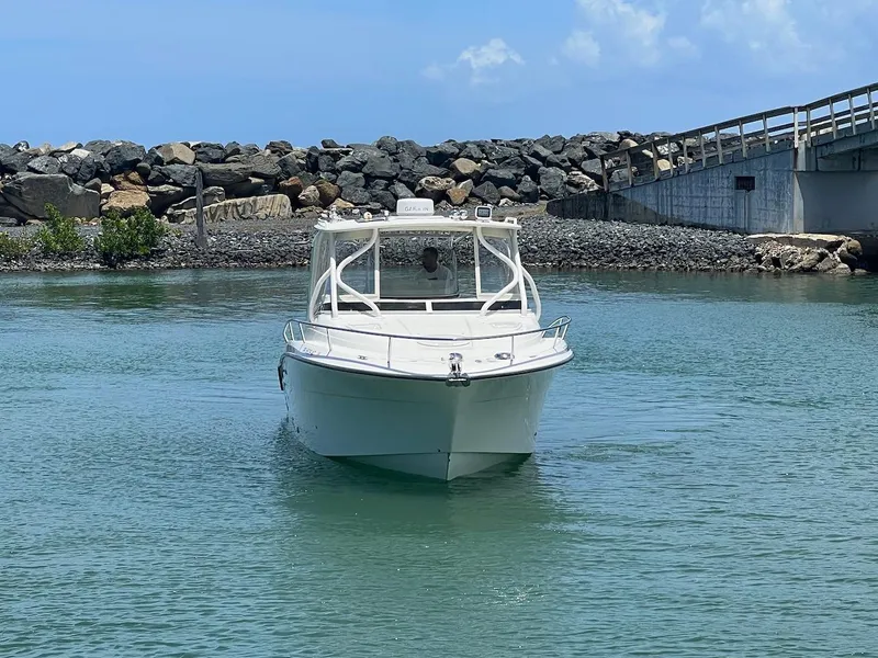 Slide: The Image of 2008 Hydra-Sports 3500VX boat navigating near rocky shoreline and bridge. - 6