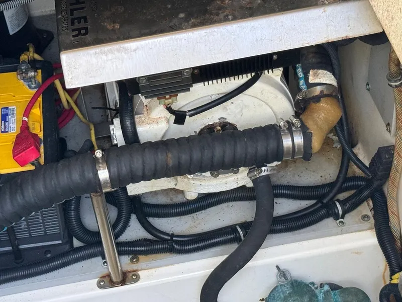 Slide: The Image of Engine compartment of a 2006 Hydra-Sports 3300 VX boat showing hoses and battery. - 14