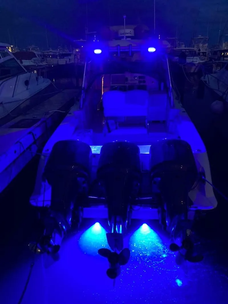 Slide: The Image of 2006 Hydra-Sports 3300 VX boat with blue underwater lights at night. - 3