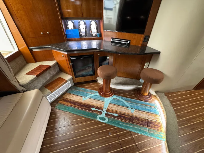 Slide: The Image of Interior of 2006 Cruisers Yachts 420 Express with wood flooring and bar stools. - 27