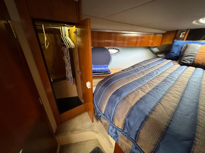 Slide: The Image of 2006 Cruisers Yachts 420 Express cabin with bed, closet, and wooden interior. - 33