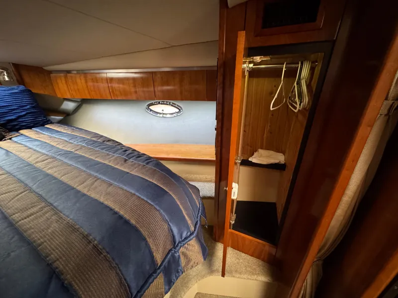 Slide: The Image of 2006 Cruisers Yachts 420 Express cabin with bed, closet, and porthole window. - 34