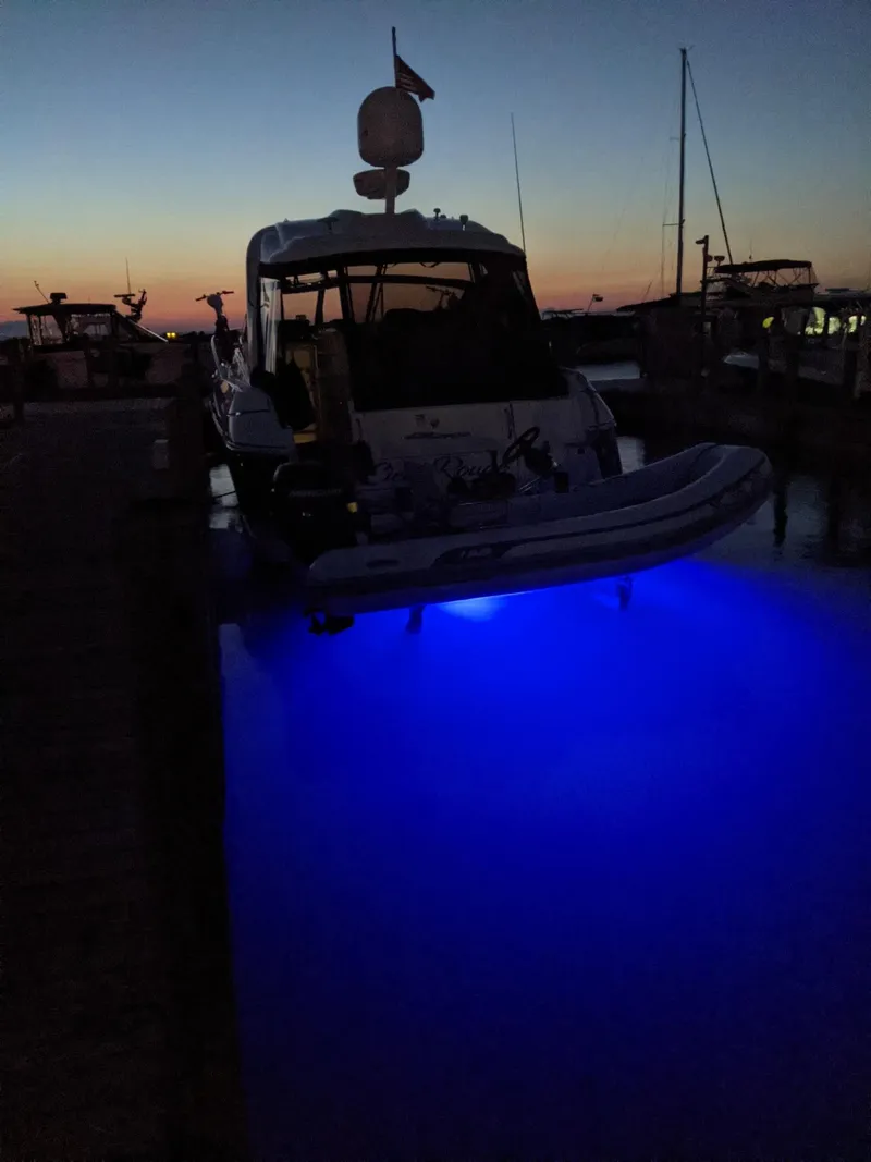 Slide: The Image of 2006 Cruisers Yachts 420 Express at sunset with blue underwater lights. - 36