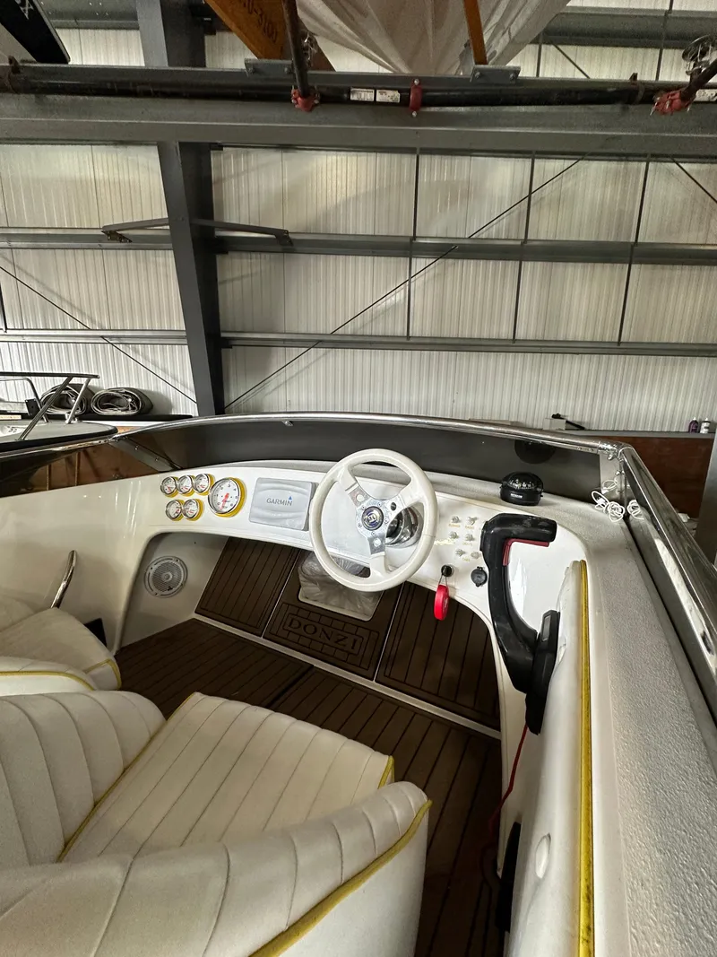 Slide: The Image of Interior of a 1995 Donzi 22 Classic boat with white seats and wooden flooring. - 3
