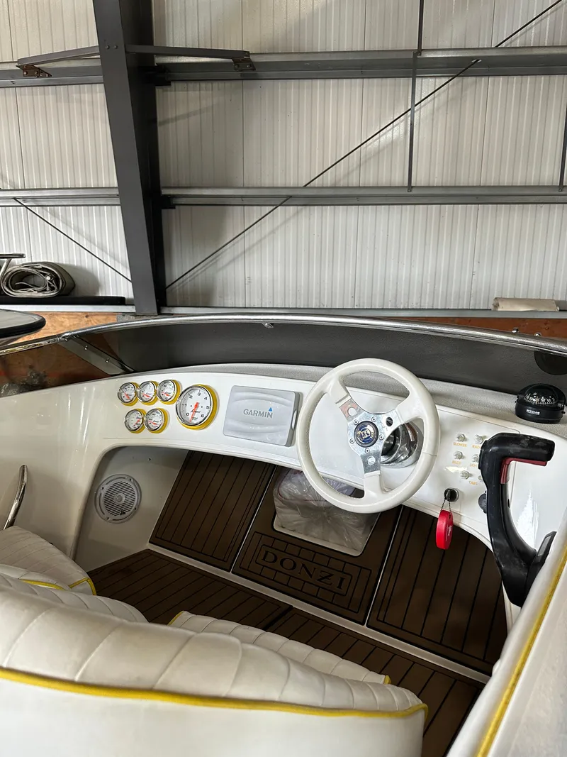 Slide: The Image of 1995 Donzi 22 Classic boat interior with white steering wheel and dashboard. - 4