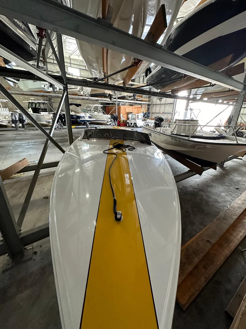 Slide: The Image of 1995 Donzi 22 Classic boat with yellow stripe in indoor storage. - 6