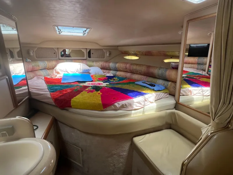 Slide: The Image of 1998 Sea Ray 330 Sundancer cabin with colorful bedding and cozy seating. - 11