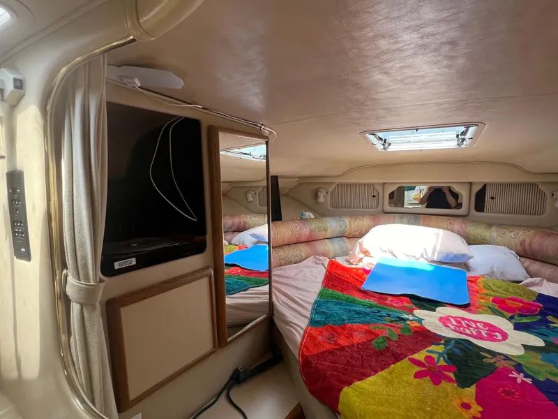 Slide: The Image of Interior cabin of a 1998 Sea Ray 330 Sundancer with colorful bedding. - 12