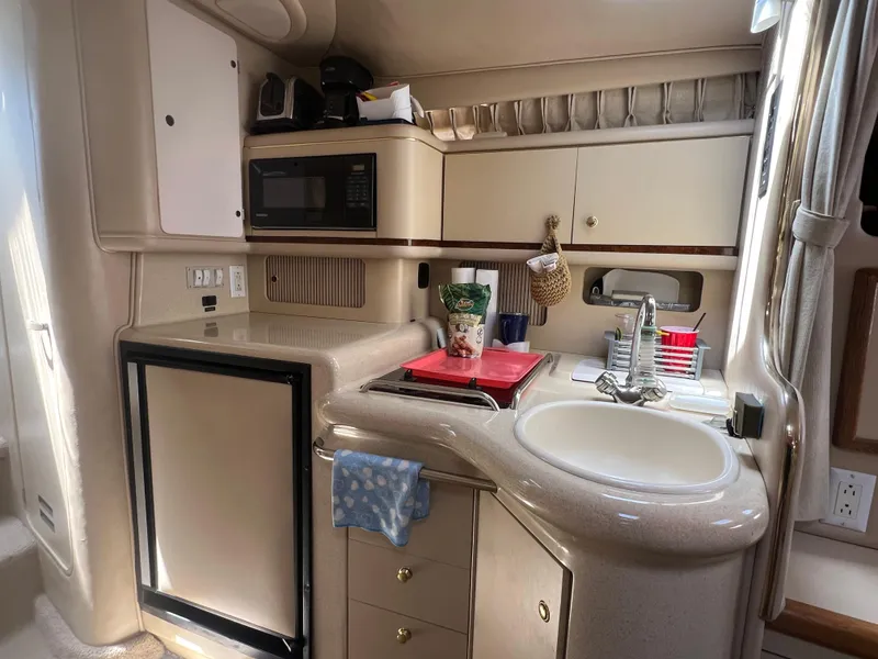 Slide: The Image of 1998 Sea Ray 330 Sundancer galley with sink, microwave, and refrigerator. - 14