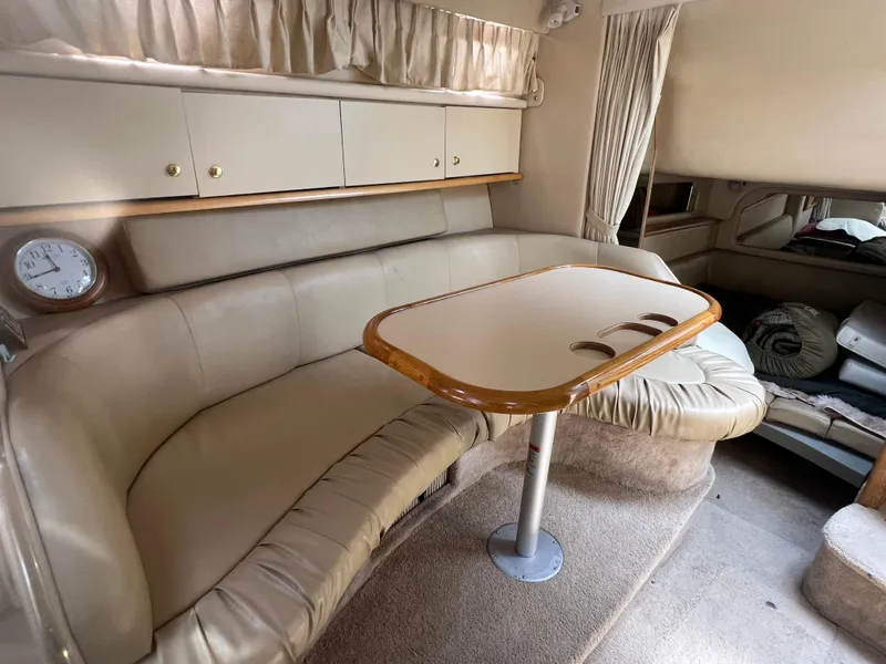 Slide: The Image of Interior of 1998 Sea Ray 330 Sundancer with beige leather seating and wooden table. - 15