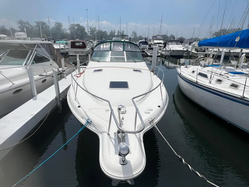 Slide: The Image of 1998 Sea Ray 330 Sundancer docked at a marina, surrounded by other boats. - 2