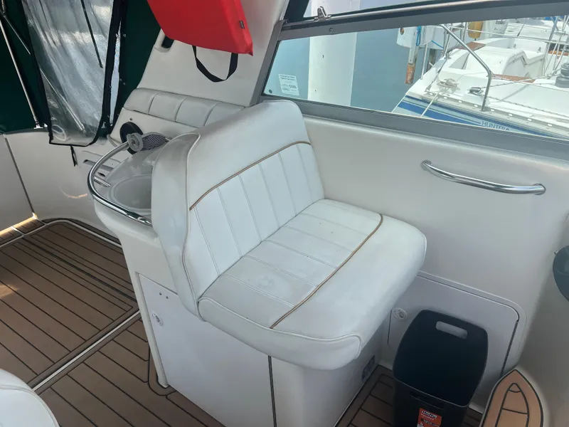 Slide: The Image of 1998 Sea Ray 330 Sundancer interior with white seating and wooden flooring. - 7