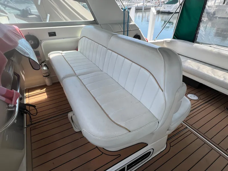 Slide: The Image of 1998 Sea Ray 330 Sundancer interior with white leather seating and wooden flooring. - 8