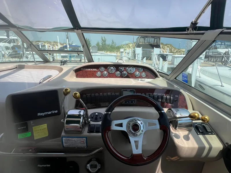Slide: The Image of 1998 Sea Ray 330 Sundancer helm with Raymarine electronics and classic wood accents. - 9