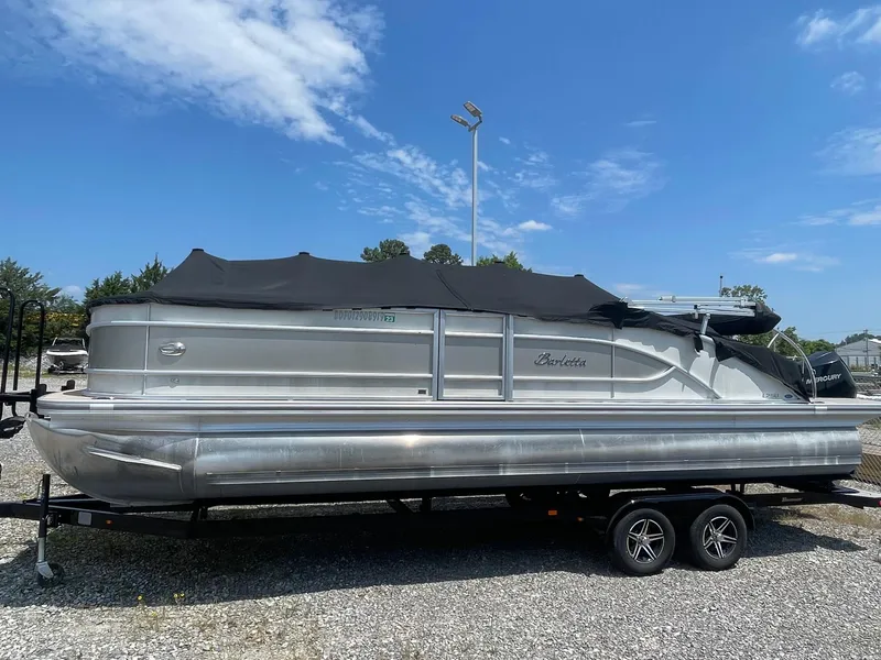 Slide: The Image of 2019 Barletta L25U pontoon boat on a trailer under a clear blue sky. - 10